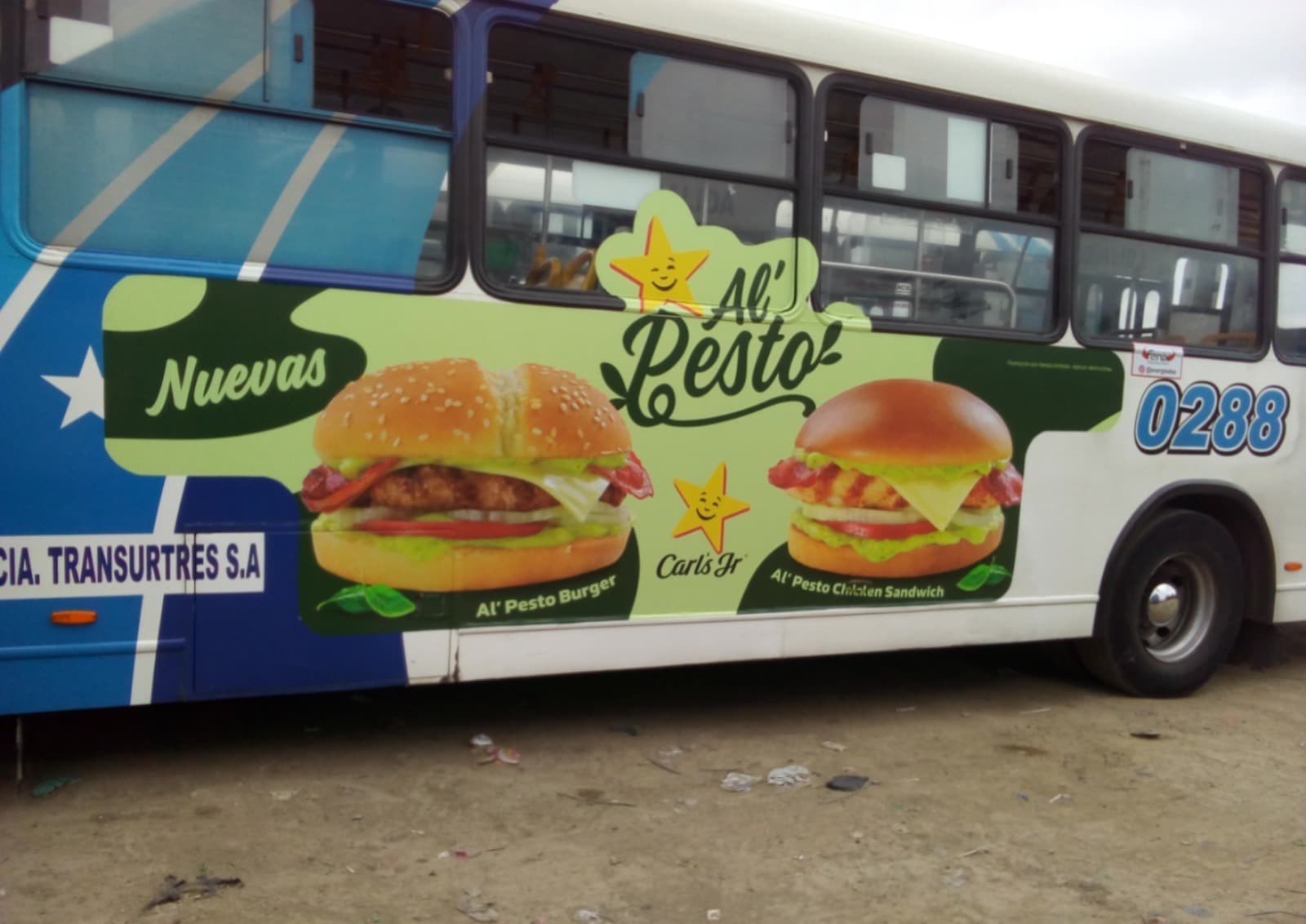 Publicidad lateral de hamburguesas Carl's Jr con salsa pesto en bus urbano